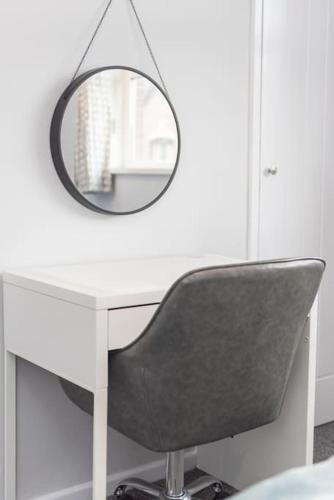 a white desk with a mirror and a chair at Excellent, comfortable location to visit Belfast in Holywood