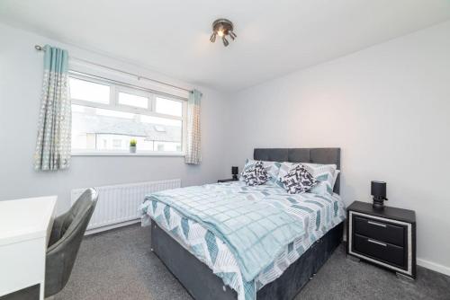 a bedroom with a bed and a desk and a window at Excellent, comfortable location to visit Belfast in Holywood