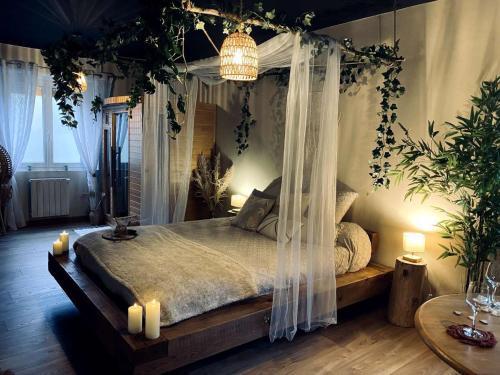 - une chambre dotée d'un lit à baldaquin avec des bougies et des plantes dans l'établissement Hors du temps, Suites Romantiques, à Campremy