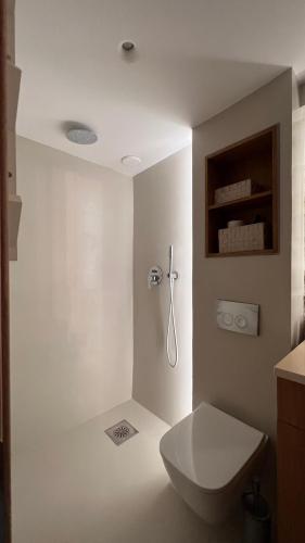 a white bathroom with a toilet and a sink at Prina Stone Retreat in Prína