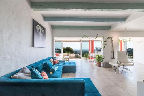- un canapé bleu dans le salon avec vue sur l'océan dans l'établissement Villa Paloma - Great location - Sea View - Alps, à Antibes