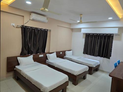 a room with two beds and a window at DatsunG Studios Near Pune Airport in Pune