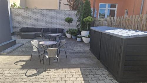 a patio with tables and chairs and a fence at EFIPA Glamour Apartments in Plzeň