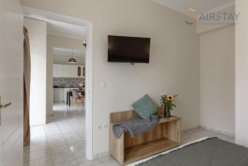a living room with a flat screen tv on a wall at Zilean Apartments Airport by Airstay in Spáta