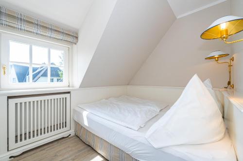 une chambre blanche avec un lit et une fenêtre dans l'établissement Roseneck App 6, à Tinnum