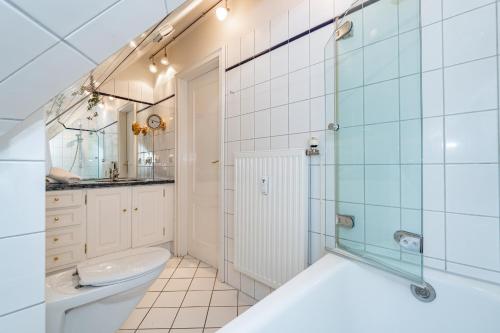 une salle de bain avec une baignoire, un lavabo et des toilettes dans l'établissement Roseneck App 6, à Tinnum
