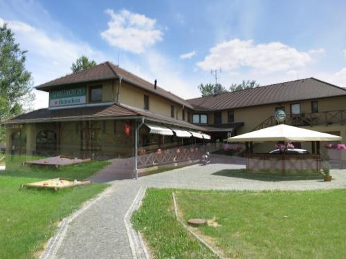 un edificio con sombrillas delante en Guest House Meat Heads Pub, en Komárno