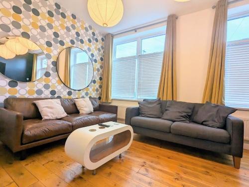 a living room with a couch and a tv at Ramsgate Retreat - ultra modern 3 bed in Ramsgate