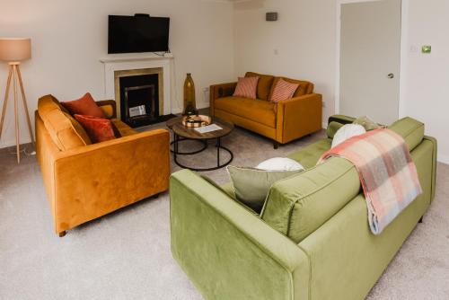 a living room with two couches and a fireplace at Old Kyle Farm - Stunning Views - 2 mins from Skye Bridge in Kyleakin