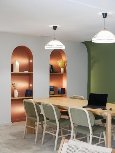 a dining room with a table with chairs and a laptop at Best Western Le Bois de la Marche in Poitiers