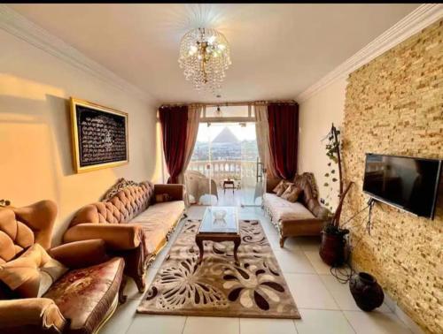a large living room with couches and a tv at Pyramids Suite in Cairo