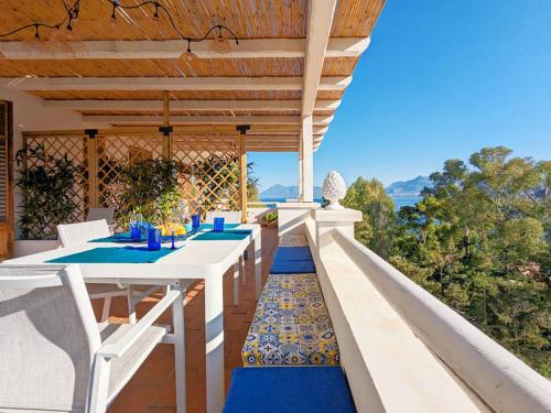 a patio with a table and chairs on a balcony at Solemar Sicilia - Villa dei due Golfi in Santa Flavia