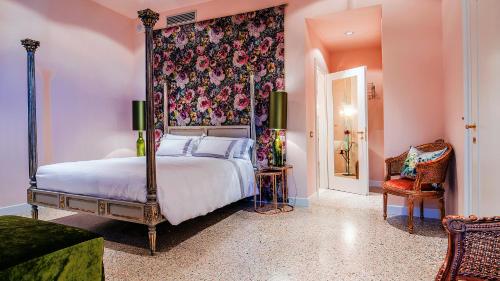 a bedroom with a large bed with a floral wall at Hotel Heureka in Venice