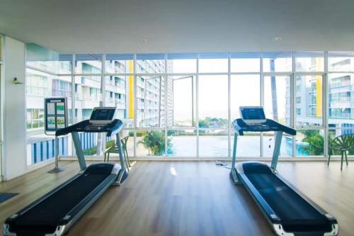 a gym with two treadmills in a large building at Studio Seaview Jomtien floor12 23sqm in Jomtien Beach