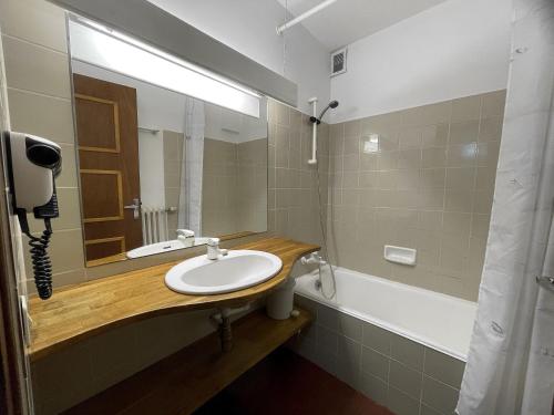 une salle de bain avec un lavabo, un miroir et une baignoire dans l'établissement Alpee 1 - Appartement proche pistes de ski, à La Clusaz