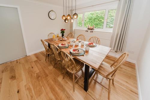 a dining room with a wooden table and chairs at Old Kyle Farm - Stunning Views - 2 mins from Skye Bridge in Kyleakin