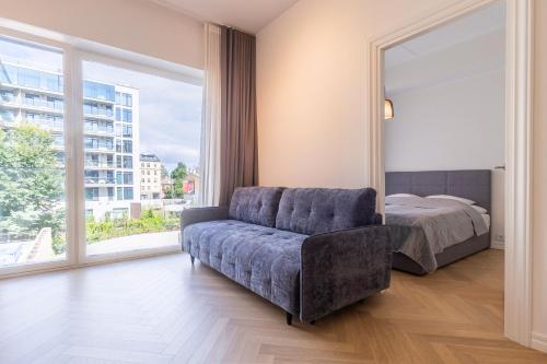 a bedroom with a couch and a bed and a window at Revalia Lastekodu-Odra Bus Station Airport Apartments in Tallinn