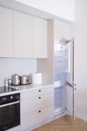 a white kitchen with white cabinets and appliances at Revalia Lastekodu-Odra Bus Station Airport Apartments in Tallinn
