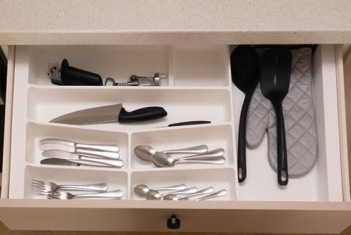 a white drawer filled with silver utensils at Revalia Lastekodu-Odra Bus Station Airport Apartments in Tallinn