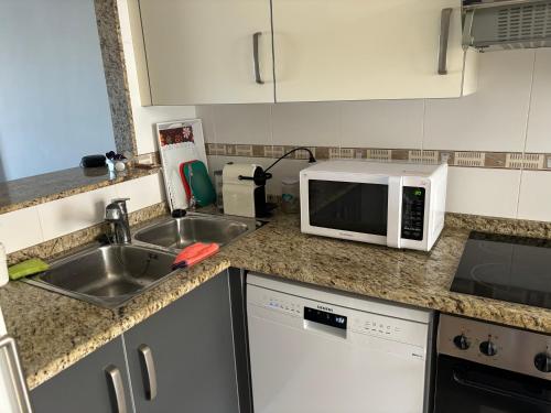 a kitchen with a sink and a microwave at Casita Azul in Moncófar