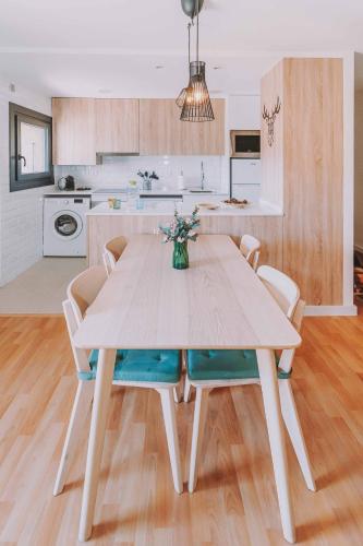 a dining room table with chairs and a kitchen at Cim's Apartments Cerdanya 1 in Bellver de Cerdanya 