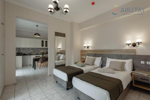 a hotel room with two beds and a kitchen at Zilean Apartments Airport by Airstay in Spáta