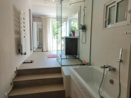 Maison en pierre, 3 chambres à 15 mn du centre de Menton et des plages في سان أجنيس: حمام مع حوض استحمام ودش زجاجي