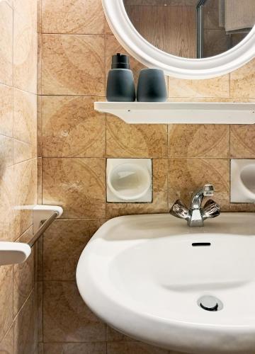 a bathroom with a sink and a mirror at haus e Apartment 3 in Lana