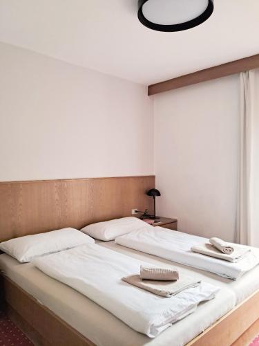 a large bed with two towels on top of it at haus e Apartment 3 in Lana
