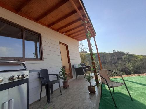 a screened in porch with chairs and a stove at Asclepia lodge spa in Quebrada Escobares