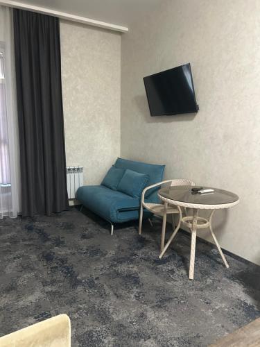 a living room with a blue couch and a table at Silveroks Apartment in Prilimanskoye