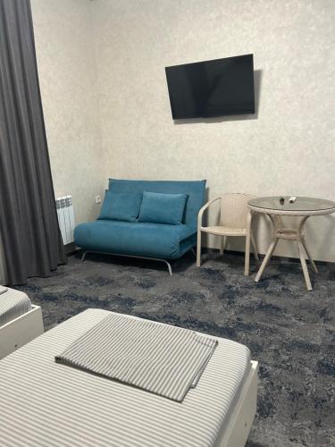 a living room with a blue couch and a table at Silveroks Apartment in Prilimanskoye