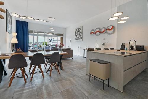 a kitchen and living room with a table and chairs at Kabbelaarsbank 504 - Port Marina Zélande in Ouddorp