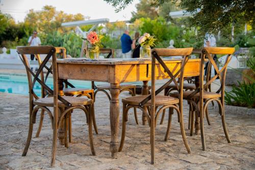 a wooden table with four chairs around it at Tenuta del Lauro in Locorotondo