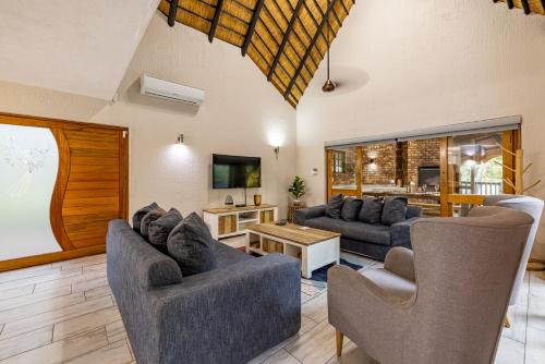 a living room with two couches and a tv at Kruger Park Lodge - IKZ2 - 3 Bedroom Chalet in Hazyview