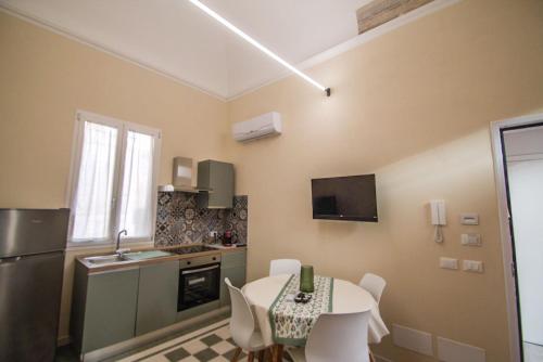 a kitchen with a table and chairs in a room at Riccio 7'0 Apartment in Trapani