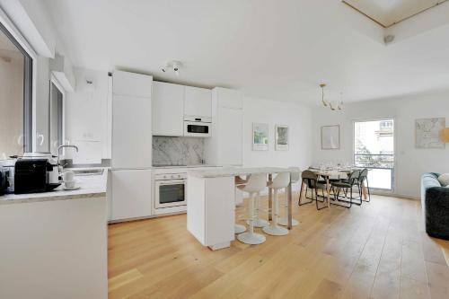 une cuisine avec des placards blancs et une salle à manger dans l'établissement Chic Duplex with Rooftop -3BD-6P- Nogent-sur-Marne, à Nogent-sur-Marne