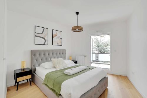 une chambre blanche avec un grand lit et une fenêtre dans l'établissement Chic Duplex with Rooftop -3BD-6P- Nogent-sur-Marne, à Nogent-sur-Marne