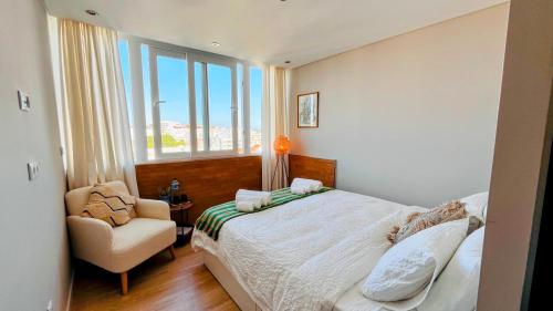 a bedroom with a bed and a chair and a window at Casa do Mocho Private Room in Lisbon in Paço de Arcos