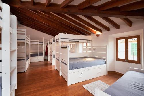 a room with white bunk beds in a room at Hostel Sóller in Sóller