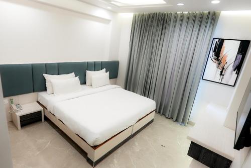 a bedroom with a large white bed and a window at Hotel Elinor By Dazzling Hotels & Resorts in Agra