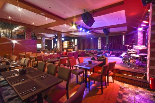 a restaurant with tables and chairs and a stage at Monaco Hotel in Taytay