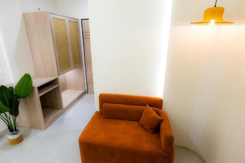 an orange chair in a living room with a table at Hotel Elinor By Dazzling Hotels & Resorts in Agra
