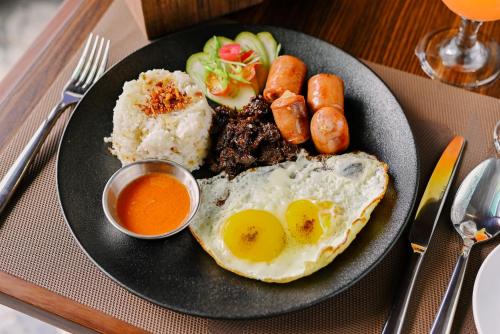 a plate of food with eggs and meat and rice at Monaco Hotel in Taytay