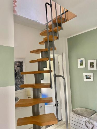 a wooden spiral staircase in a room with green walls at Ferienhaus in Wald und Seenähe in Templin