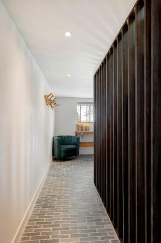 a hallway with a green chair in a room at Luxe vakantiehuis in dijkboerderij in Zuid-Beijerland