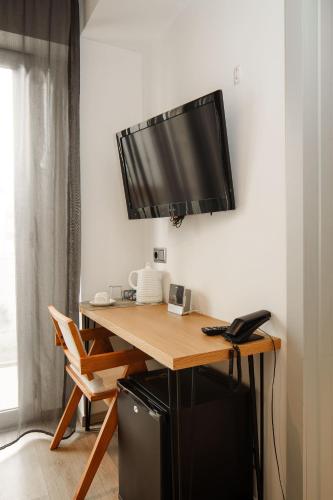 a desk with a flat screen tv on a wall at Mar Calma Hotel in Port de Pollensa