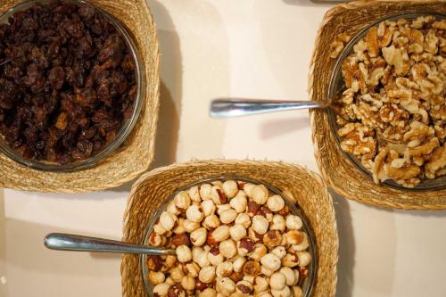 four bowls filled with nuts and other food on a table at Mar Calma Hotel in Port de Pollensa
