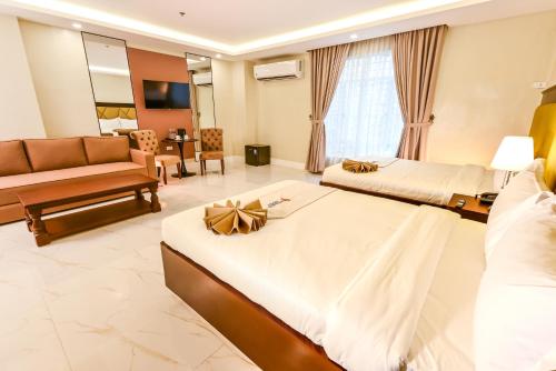 a hotel room with two beds and a couch at Monaco Hotel in Taytay