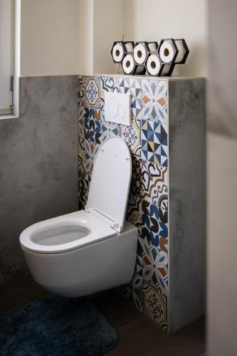 a bathroom with a toilet with a tile wall at CHALET-KOPPI in Apetlon